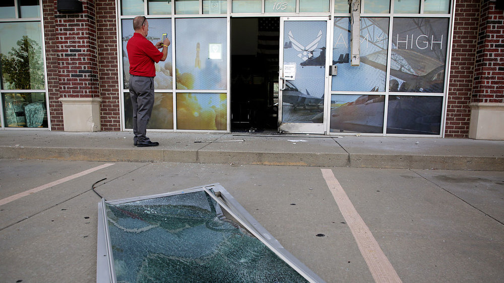 Glass and a door lie on the ground at the scene of an explosion at an Air Force recruiting office in Bixby, Okla., Tuesday, July 11, 2017, after an explosion Monday night outside an Air Force recruitment office. (Mike Simons//Tulsa World)