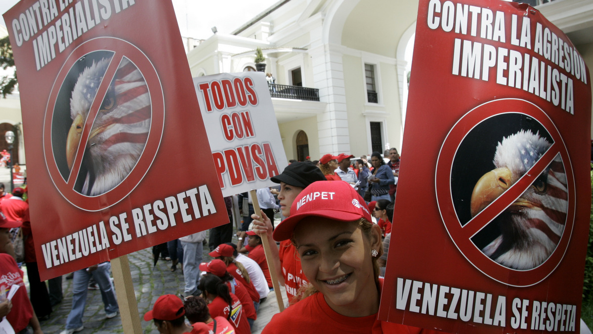 A Venezuelan protester holds a poster that reads in Spanish "Against Imperialist aggression, respect Venezuela" during a protest outside the National Assembly in Caracas Venezuela. (AP/Howard Yanes)