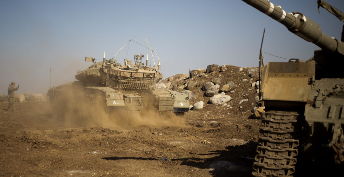 An Israeli soldier directs a tank near the border with Syria in the Israeli-occupied Golan Heights, Nov. 28, 2016. (AP/Ariel Schalit)