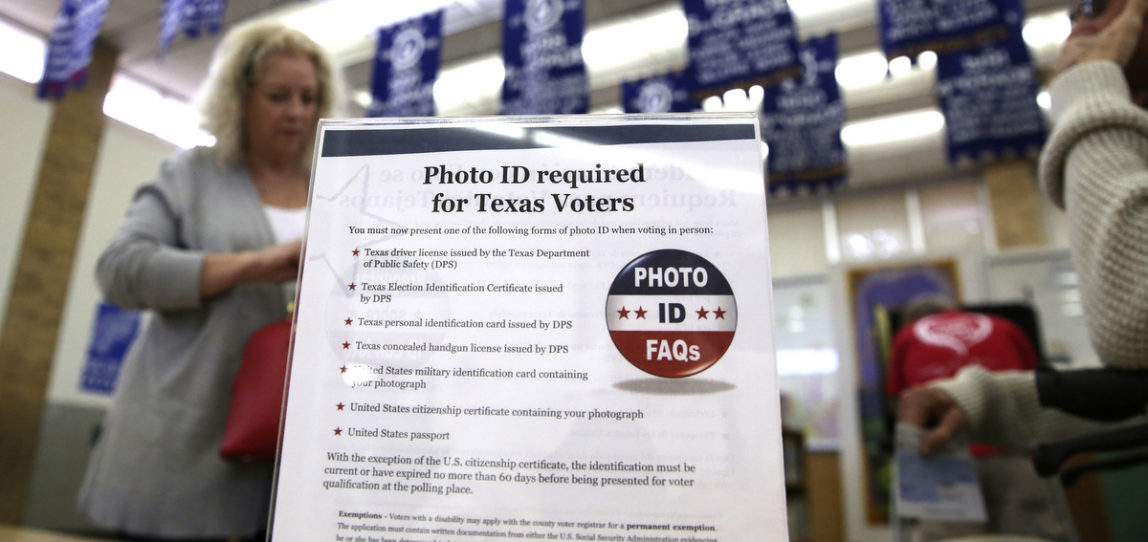 A sign tells voters of voter ID requirements before participating in the primary election at Sherrod Elementary school in Arlington, Texas, March 1, 2016. (AP/LM Otero)