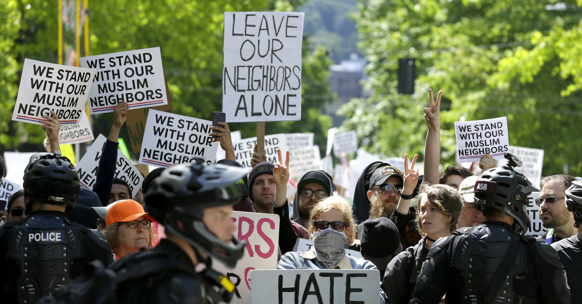Counter-protestors stand behind a line of Seattle Police officers across the street from an anti-Islamic law protest rally, June 10, 2017, in Seattle. (AP/Ted S. Warren)