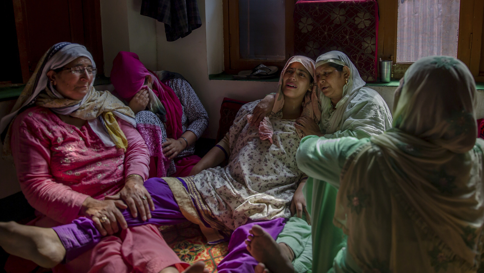 Unidentified relatives comfort wailing Rukaya Firdous, pregnant wife of a Kashmiri civilian who was killed during a protest by Indian police in Begumbagh, about 32 kilometers (20miles) south of Srinagar, Indian occupied Kashmir, Aug. 1, 2017. (AP/Dar Yasin)