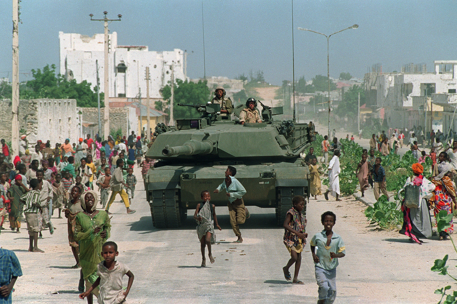 Niños somalíes corren junto a un tanque Abrams M-1 de la Marina de los Estados Unidos durante una patrulla blindada en el norte de Mogadiscio, Somalia, el 26 de enero de 1993. (AP / Mark Duncan)