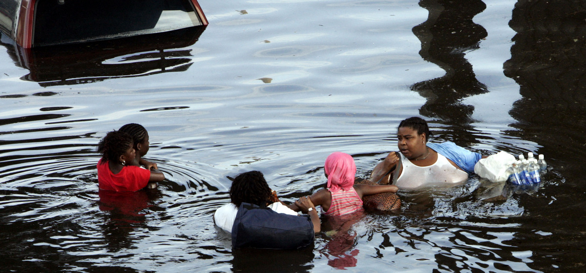 A New Orleans family tries to make their way through floodwaters in the downtown area of the Crescent City on Aug. 30, 2005. The water continued to rise after Hurricane Katrina pounded the area. (AP/Bill Haber)