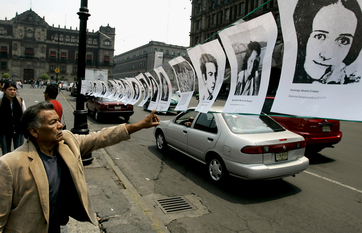 A man looks at photos of people who dissappeared during the "Dirty War" in Argentina during an event to commemorate the 30th anniversary of the Argentine military coup, in Mexico City, Mexico on Friday March 24, 2006. At least 13,000 people are officially listed as disappeared or dead during the so-called "Dirty War" that right-wing military officers waged on leftists and other political dissidents after the coup. Human rights organizations put the toll of dead and missing at nearly 30,000. (AP/Eduardo Verdugo)