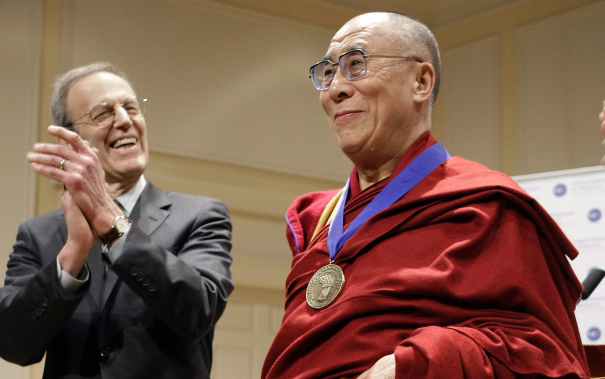 The Dalai Lama displays his Democracy Service Medal, presented by the president National Endowment for Democracy, Carl Gershman, Friday, Feb. 19, 2010. (AP Photo/J. Scott Applewhite)
