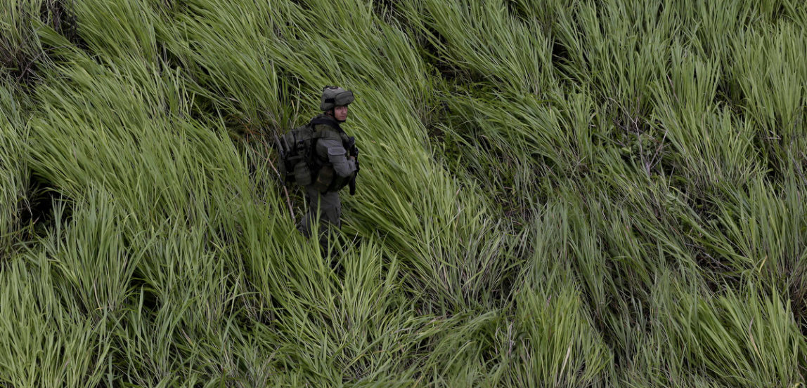 An anti-narcotics police officer stands guard at a landing zone near a cocaine lab in Calamar, Guaviare state, Colombia. Police seized cocaine and chemicals at the lab. About 104 labs have been destroyed by the police in a five day period.(AP/Fernando Vergara)