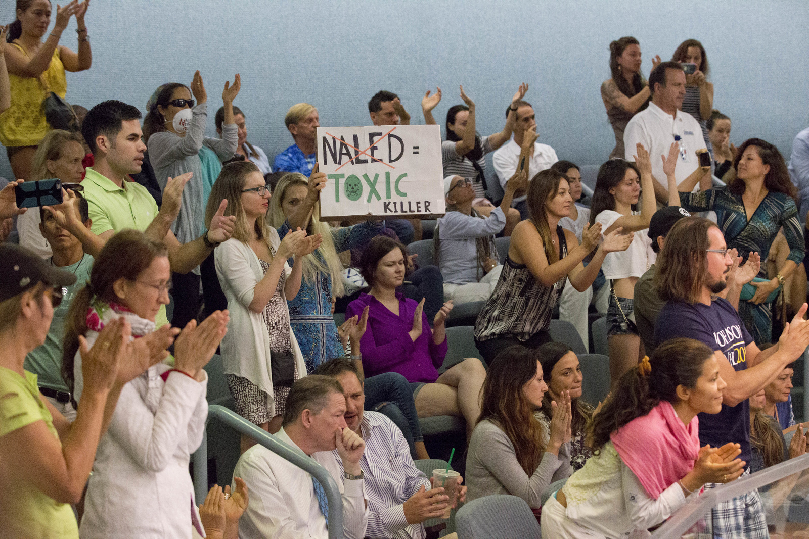 Los manifestantes aplauden en una reunión de la comisión de la ciudad en Miami Beach, Florida. Los opositores quieren detener la fumigación aérea del insecticida naled, utilizado para combatir el mosquito Aedes aegypti, 14 de septiembre de 2016. (Foto AP / Wilfredo Lee)