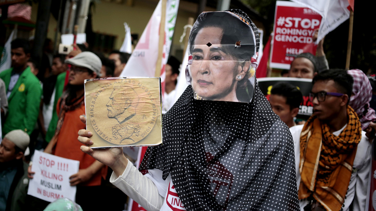 A woman wears a mask of Myanmar's Foreign Minister Aung San Suu Kyi during a rally against the persecution of Rohingya Muslims, outside the Embassy of Myanmar in Jakarta, Indonesia, Nov. 25, 2016. (AP/Dita Alangkara)