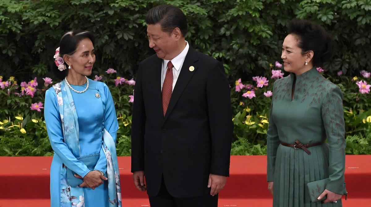 Myanmar's State Counsellor Aung San Suu Kyi, left, talks with Chinese President Xi Jinping and his wife Peng Liyuan during a welcome ceremony for leaders attending the Belt and Road Forum, at the Great Hall of the People in Beijing, Sunday, May 14, 2017. (Wang Zhao/Pool Photo via AP)