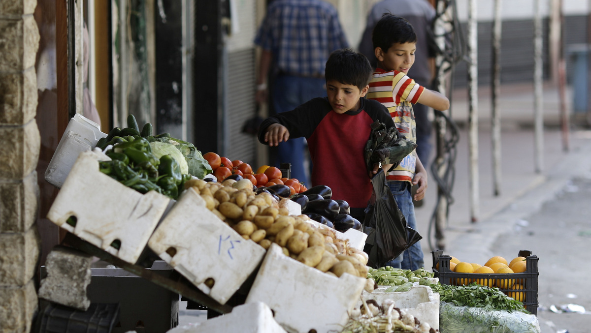 Syrian children buy vegetables at the town of Madaya in the Damascus countryside, Syria, May 18, 2017. (AP/Hassan Ammar)