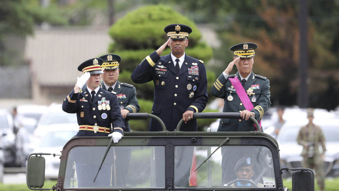 U.S. Gen. Vincent Brooks, commander of Combined Forces Command, center, salutes with incoming Deputy Commander Gen. Kim Byung-joo, left rear, and outgoing Deputy Commander Gen. Leem Ho-young, right, in a car, at a U.S. military base, in Seoul, South Korea, Aug. 11, 2017. U.S. and South Korean military officials later engaged in large-scale military exercises later that month. (AP/Lee Jin-man)