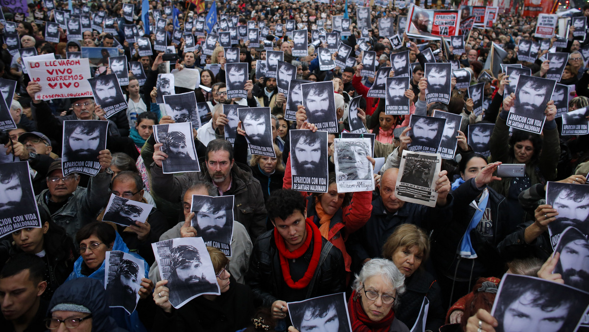 People hold photos of Santiago Maldonado, who's missing, during a demonstration at Plaza de Mayo in Buenos Aires, Argentina, Friday, Aug. 11, 2017. Maldonado went missing after Argentine police captured him on Aug. 1 during an operative against Mapuche indigenous in Argentina's Patagonia. (AP/Victor R. Caivano)