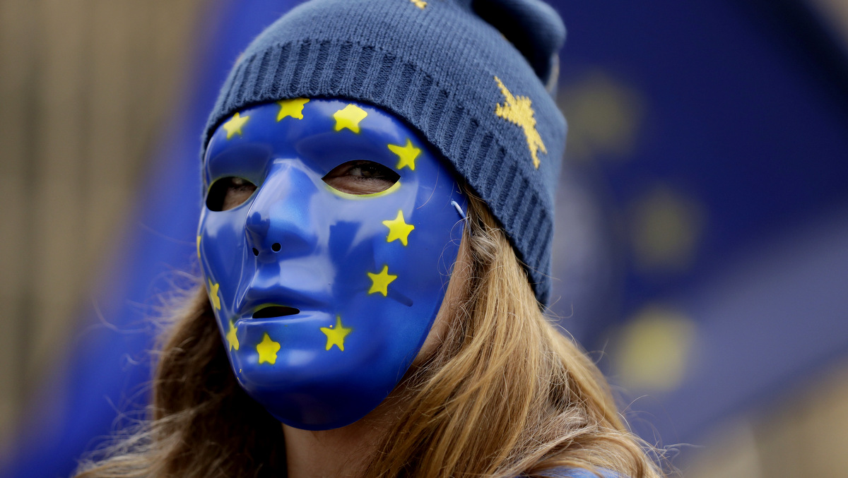 A pro-remain supporter of Britain staying in the EU, wears an EU flag mask whilst taking part in a protest to coincide with politicians returning to work after the summer recess, outside the Houses of Parliament in London, Sept. 5, 2017. (AP/Matt Dunham)