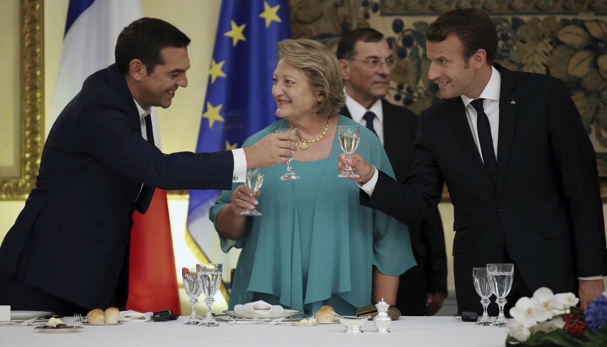 French president Emmanuel Macron, right, Greek Prime Minister Alexis Tsipras, left, and Vlasia Pavlopoulou wife of the Greek President toast their drinks at the Presidential Palace in Athens, Thursday, Sept. 7, 2017. Standing at a Greek site where democracy was conceived, French President Emmanuel Macron called on members of the European Union to reboot the 60-year-old bloc with sweeping political reforms or risk a "slow disintegration. (AP/Charalambos Gikas)