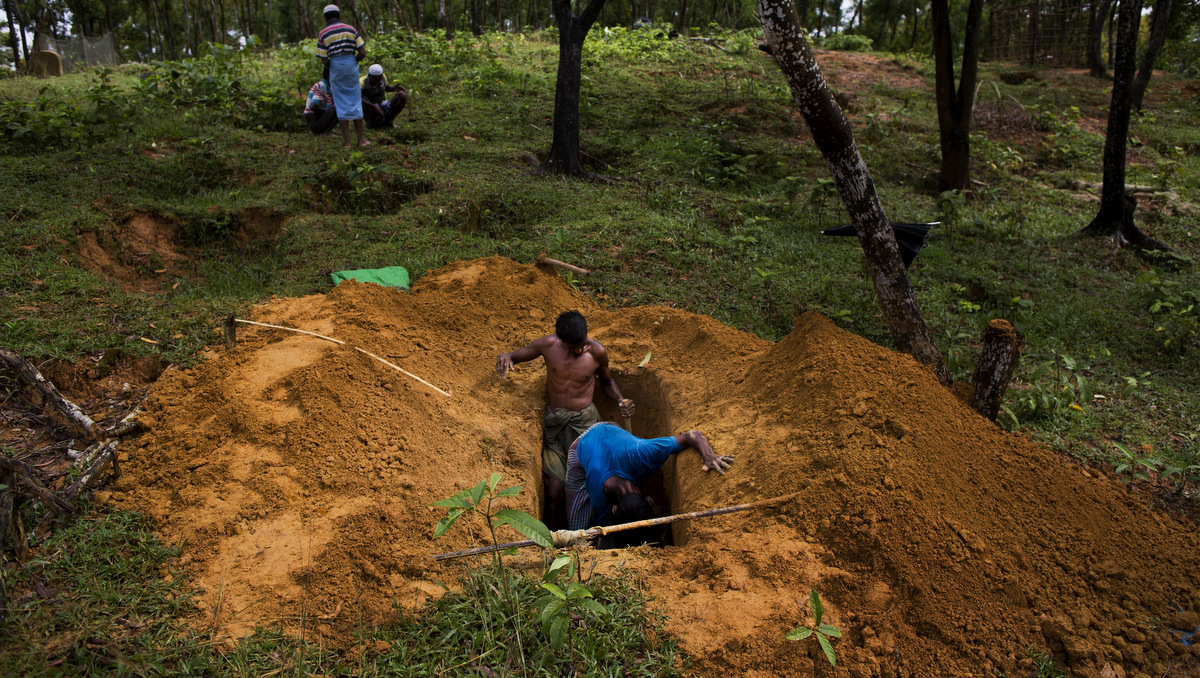 Rohingya men dig a grave in Kutupalong's refugee camp's cemetery, Bangladesh, Sept. 8, 2017. This massive refugee camp was set up in the early 90s to accommodate the first waves of Rohingya Muslim refugees who started escaping convulsions of violence and persecution in Myanmar. (AP/Bernat Armangue)