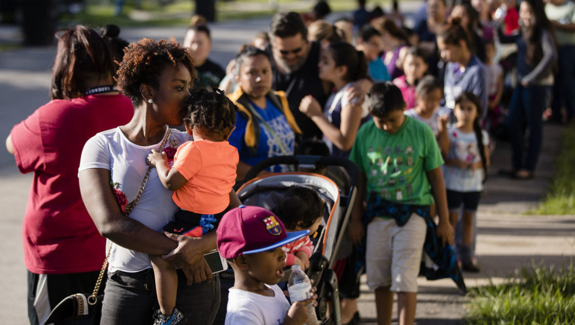 Families wait in line to receive free school uniforms and other necessities in the aftermath of Hurricane Harvey on Friday, Sept. 8, 2017, at the Denver Harbor Multi-Service Center in Houston. (AP/Matt Rourke)
