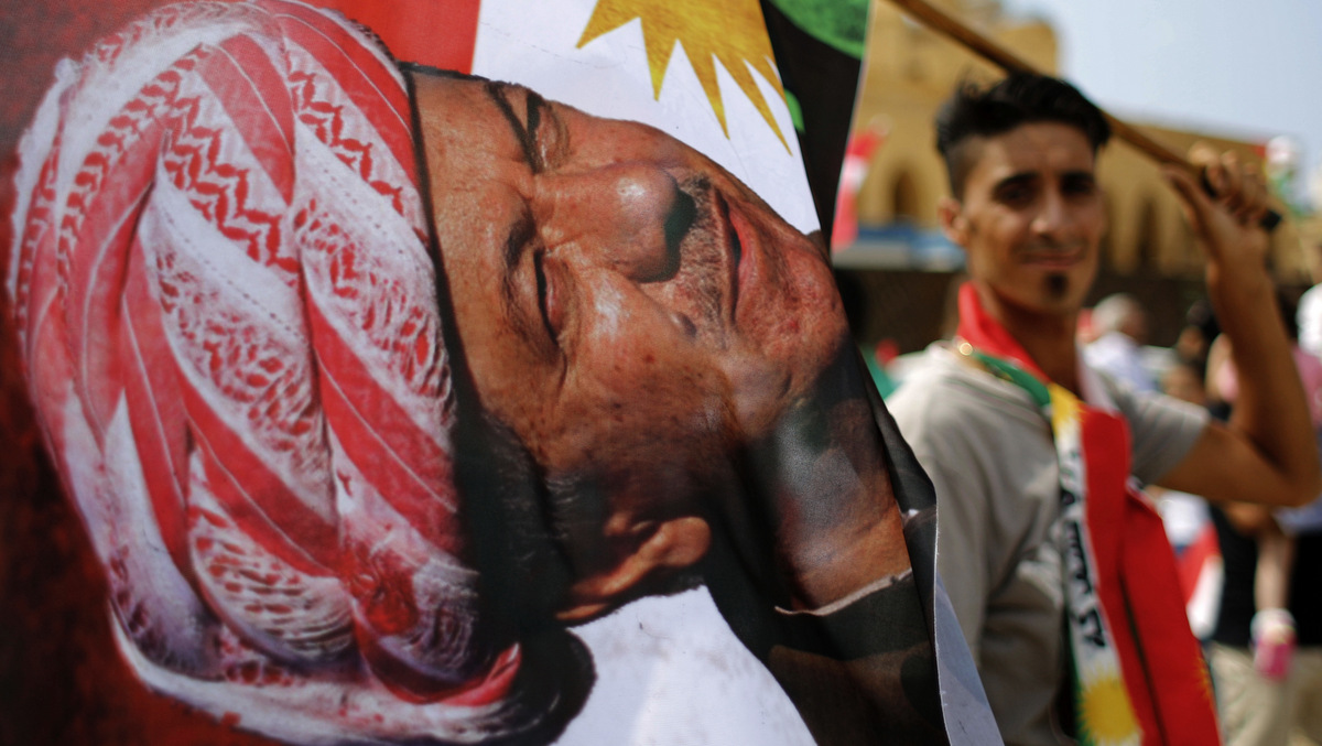 A man holds a Kurdish flag with a picture of Iraqi Kurdish leader Masoud Barzani during a gathering to support next week's referendum in Iraq, at Martyrs Square in Downtown Beirut, Lebanon, Sunday, Sept. 17, 2017. Iraq's Kurdish region plans to hold the referendum on Sept. 25 to gauge support for independence from Iraq for the autonomous region. (AP Photo/Hassan Ammar)