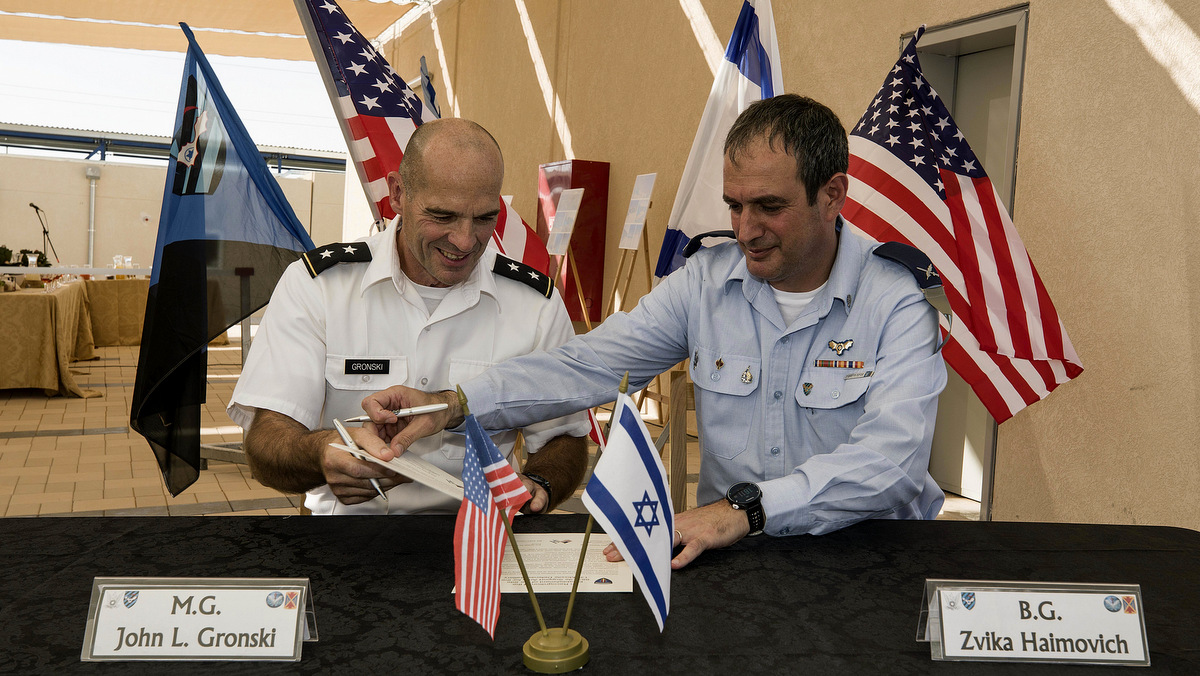 Israeli Defense Forces Brig. Gen. Zvika Haimovich, right, and U.S. Maj. Gen. John L. Gronski sign an agreement during a ceremony at the Bislach Air Base, near Mitzpe Ramon, Monday, Sept. 18, 2017. Israel and the United States announced plans Monday to open the first American air base in the Jewish state -- a facility that will aim to bolster Israel's aerial defenses. (AP Photo/Tsafrir Abayov)