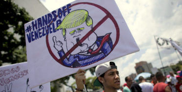 A government supporter holds a placard with the universal "No" symbol over a caricature of U.S. President Donald Trump during an anti-imperialist demonstration, in Caracas, Venezuela, Tuesday, Sept. 19, 2017. In his debut address to the U.N. General Assembly, Trump says the socialist government in Venezuela has brought a once-thriving nation to the "brink of collapse." Trump accused its President Nicolas Maduro of stealing power from elected representatives to preserve his "disastrous rule." (AP/Ariana Cubillos)