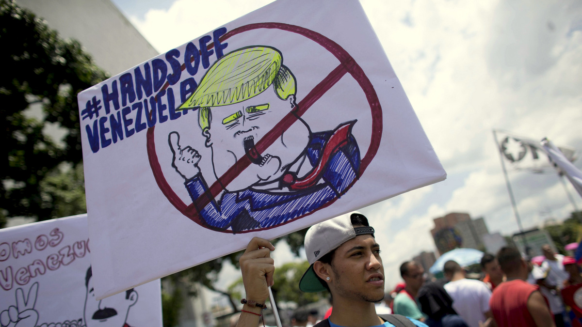 A government supporter holds a placard with the universal "No" symbol over a caricature of U.S. President Donald Trump during an anti-imperialist demonstration, in Caracas, Venezuela, Tuesday, Sept. 19, 2017. In his debut address to the U.N. General Assembly, Trump says the socialist government in Venezuela has brought a once-thriving nation to the "brink of collapse." Trump accused its President Nicolas Maduro of stealing power from elected representatives to preserve his "disastrous rule." (AP/Ariana Cubillos)