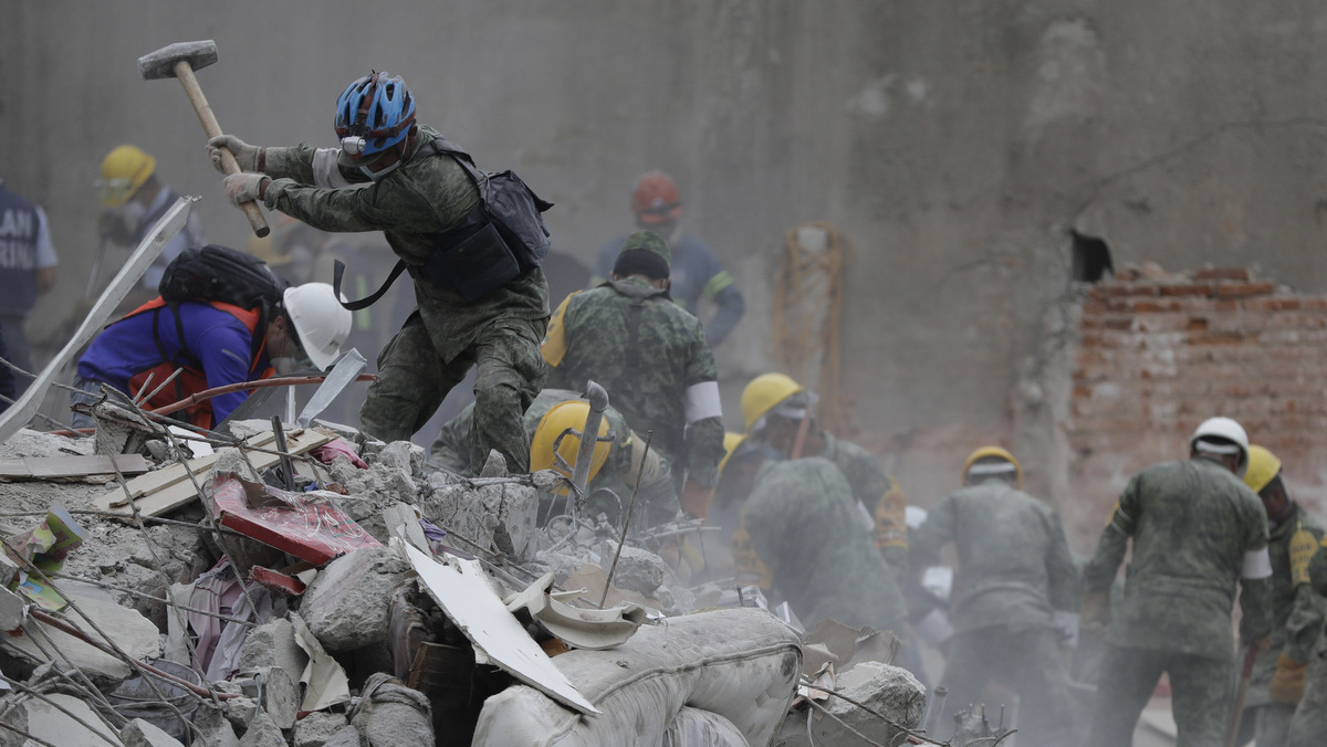 Rescue workers and volunteers search for survivors at an apartment building located on the street corner of Amsterdam and Laredo, that collapsed during an earthquake in the Condesa neighborhood of Mexico City, Sept. 21, 2017. (AP/Natacha Pisarenko)