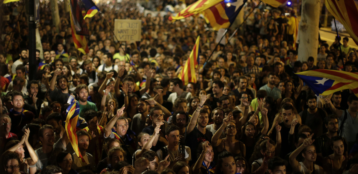 People shout slogans during a protest in Barcelona, Spain, Sept. 21, 2017. Thousands have gathered at the gates of Catalonia's judiciary body in Barcelona to demand the release of a dozen officials arrested in connection with a vote on independence that Spanish central authorities are challenging as illegal. (AP/Manu Fernandez)