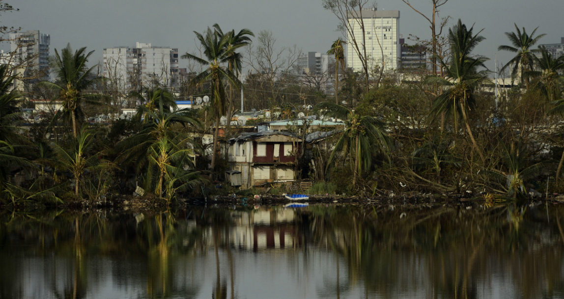 Trees are reflected in the water in the Buena Vista community in the aftermath of Hurricane Maria in San Juan, Puerto Rico, Sunday, Sept. 24, 2017. (AP Photo/Carlos Giusti)