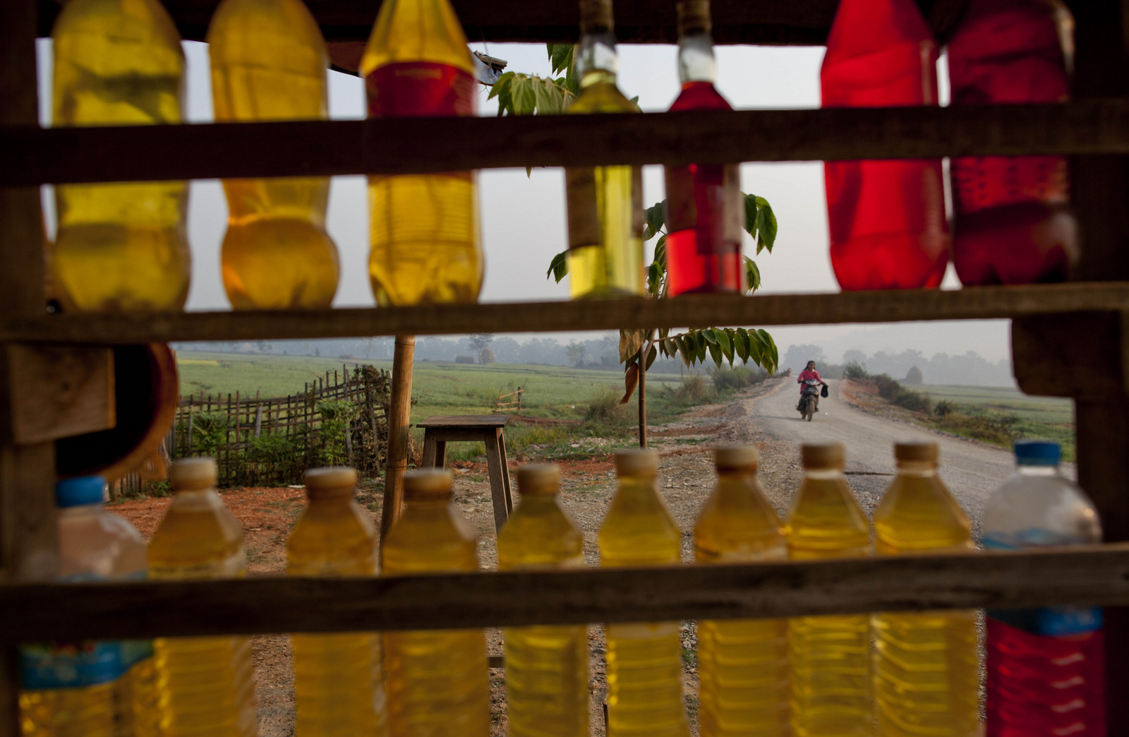 Gasoline filled in to plastic bottles are on display at a roadside shop in Mong Pan, Northern Shan estate, Myanmar. Myanmar put over 20 offshore oil and gas exploration blocks up for auction as the country pushed to attract foreign investment. (AP/Gemunu Amarasinghe)