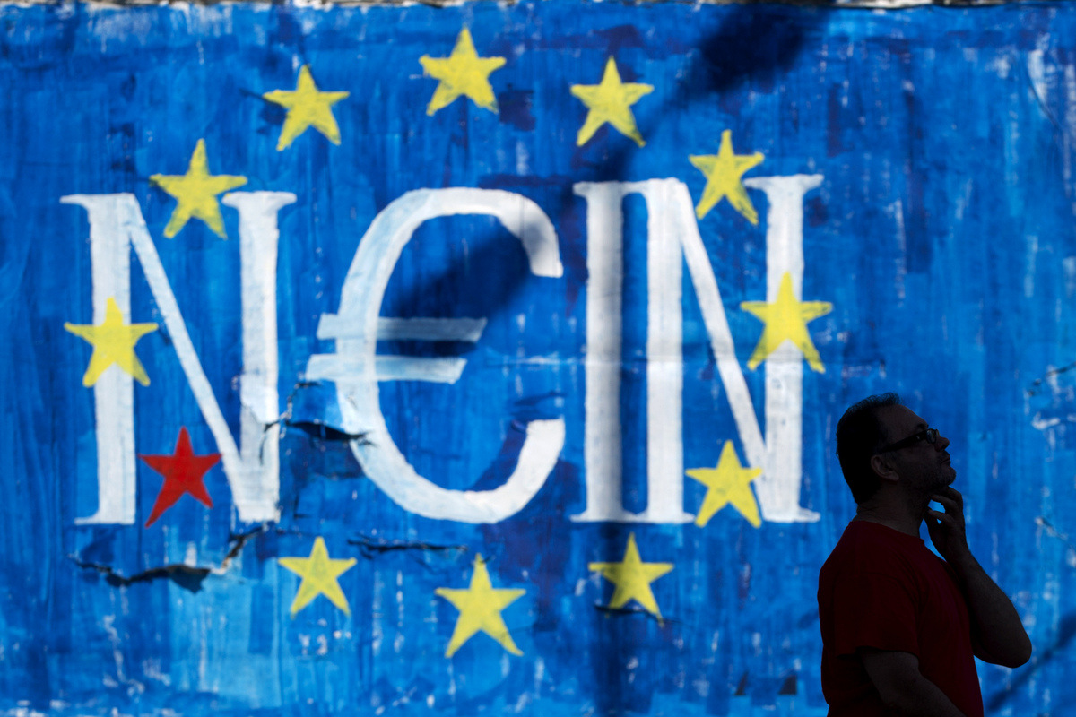 A man walks past a graffiti made by street artist N_Grams that read ''NO'' in German but also ''YES, IN'' in Greek language in Athens, June 28, 2015. (AP/Petros Giannakouris)
