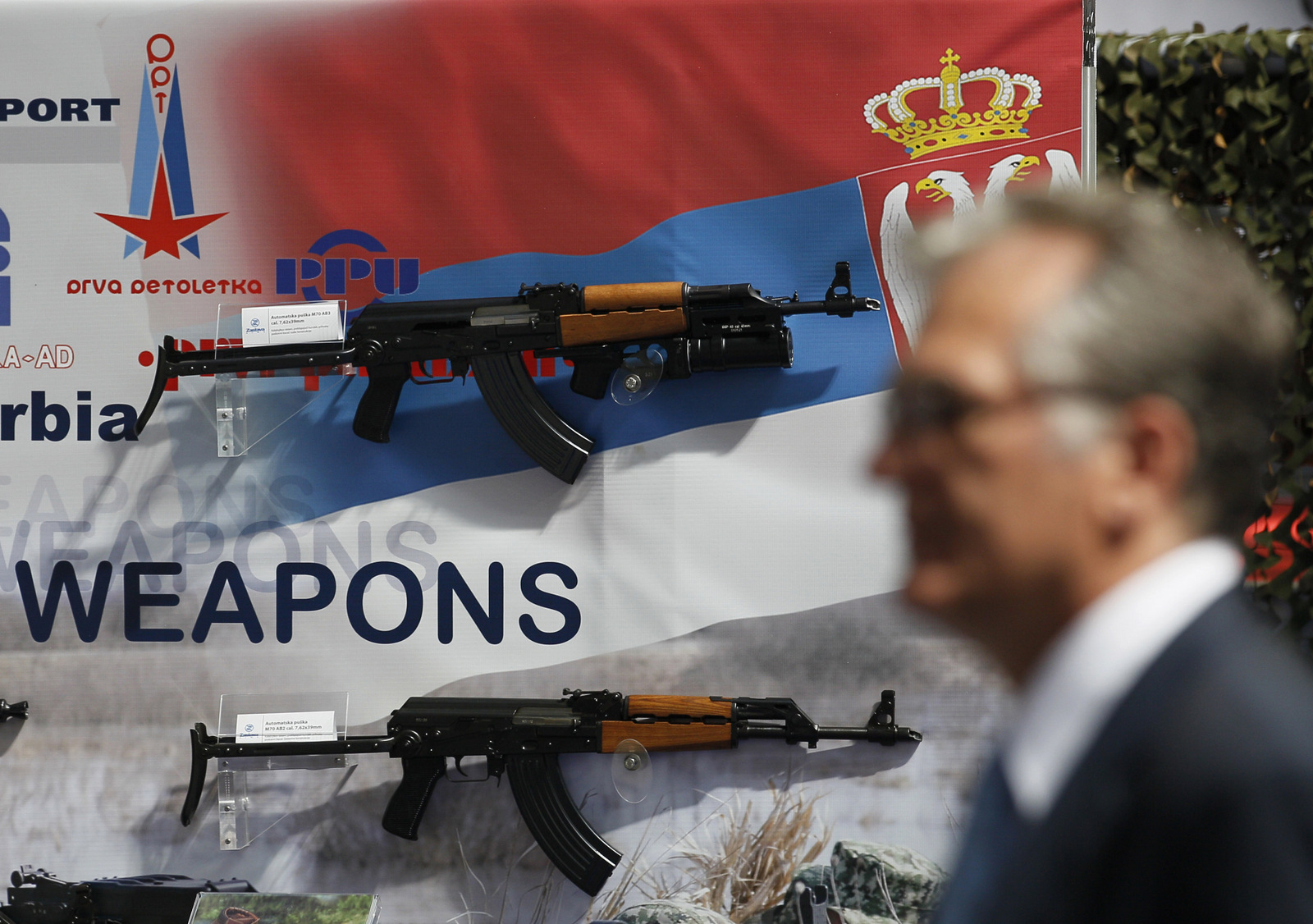 A visitor looks at assault rifles made by the Serbian company Zastava Arms, during a defense fair, in Belgrade, Serbia. (AP/Darko Vojinovic)