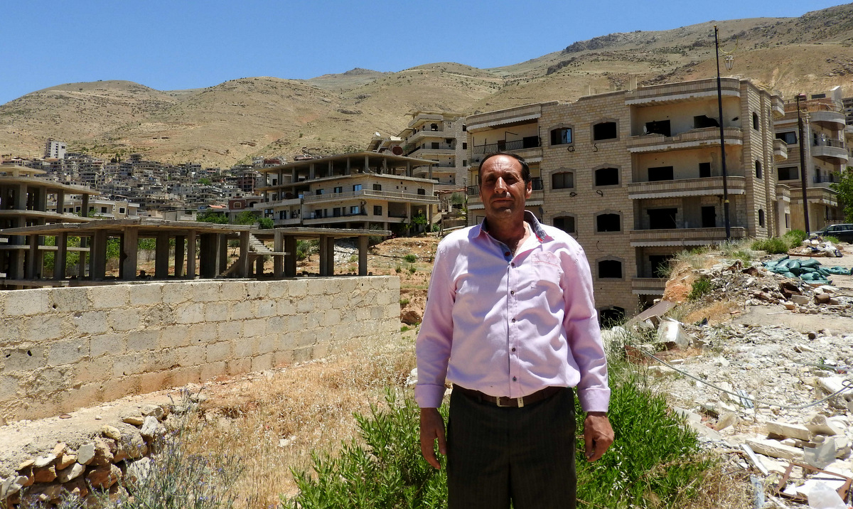 The Mayor of Madaya, standing near buildings once occupied by "moderate rebels" who sniped and fired mortars on the road below.