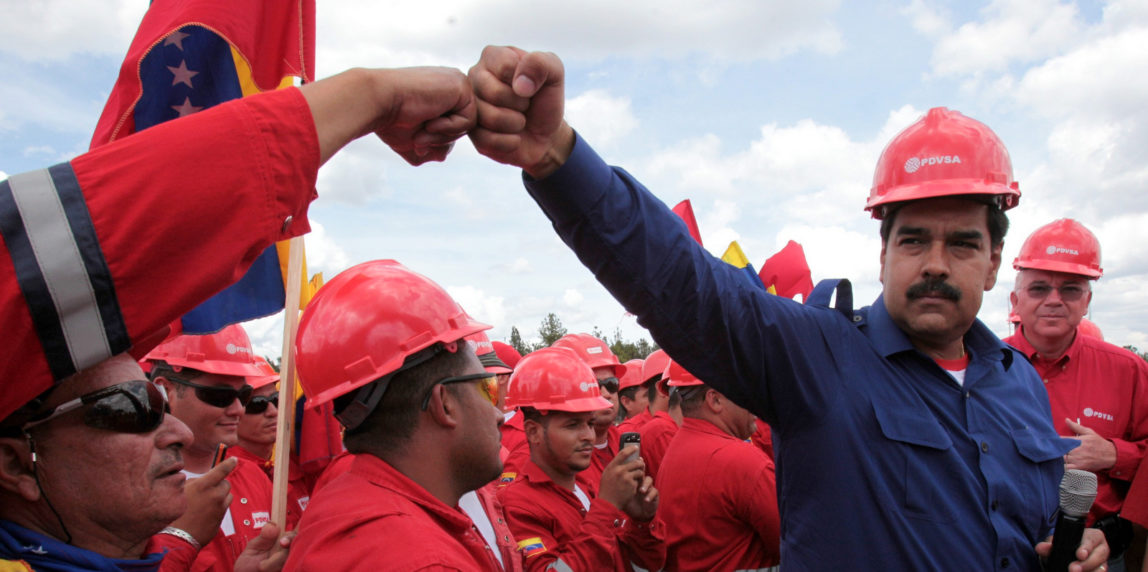 Venezuelan President Nicolas Maduro fist bumps a worker of the state-run oil company PDVSA during a visit to the Orinoco oil belt in Venezuela in 2013. (Photo: Miraflores/AP)