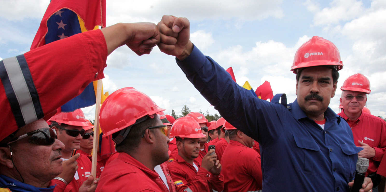 Venezuelan President Nicolas Maduro fist bumps a worker of the state-run oil company PDVSA during a visit to the Orinoco oil belt in Venezuela in 2013. [Photo: Miraflores/AP)