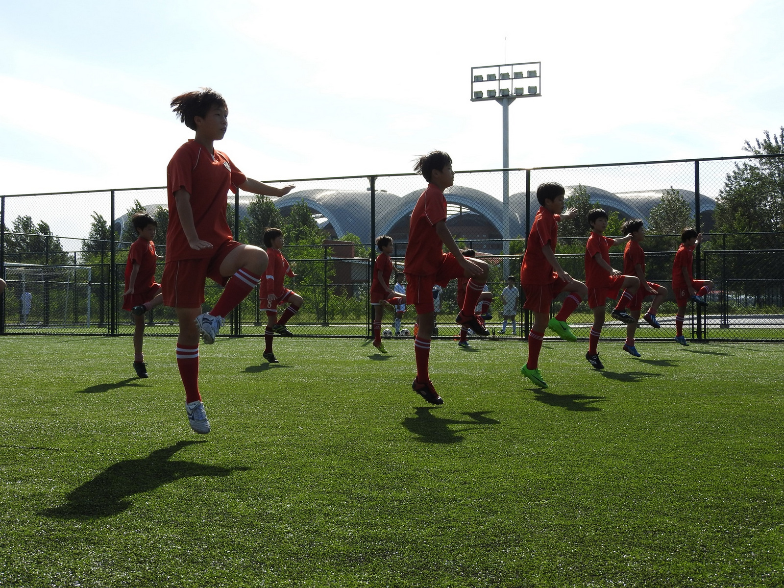 La Escuela Internacional de Fútbol de Pyongyang abrió sus puertas en 2013. El complejo incluye un estadio masivo y una escuela que enseña todas las materias, con el fútbol como foco para aproximadamente 200 estudiantes. Diferentes clases practicaron sus habilidades afuera, haciendo ejercicios de calentamiento con música enérgica. Cuando hace años vivía en el sur de Corea, practicando Tae Kwan Do. Me preparé para simulacros similares.