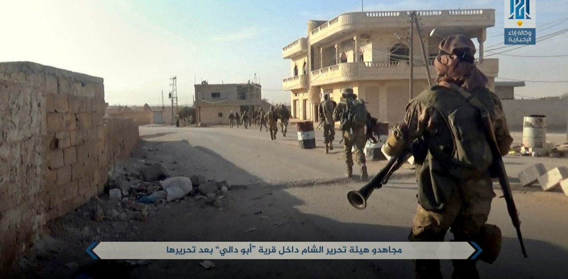 al-Qaida-linked fighters from Hayat Tahrir al-Sham walk inside the Syrian village of Abu Dali in Idlib province, after they captured it from Syrian troops, Sunday, Oct 8, 2017. (Ibaa News Agency, via AP)