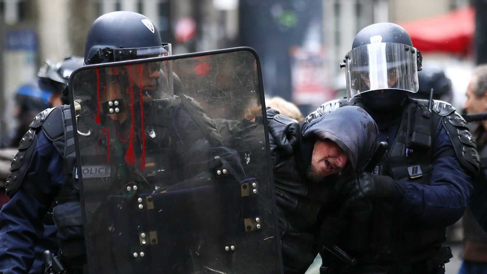 Riot police officers detain a demonstrator during a protest in Paris, Tuesday, Oct.10, 2017. Police are using tear gas and batons to push back protesters throwing projectiles at a demonstration in Paris over public sector job cuts and salary freezes. (AP Photo/Francois Mori)