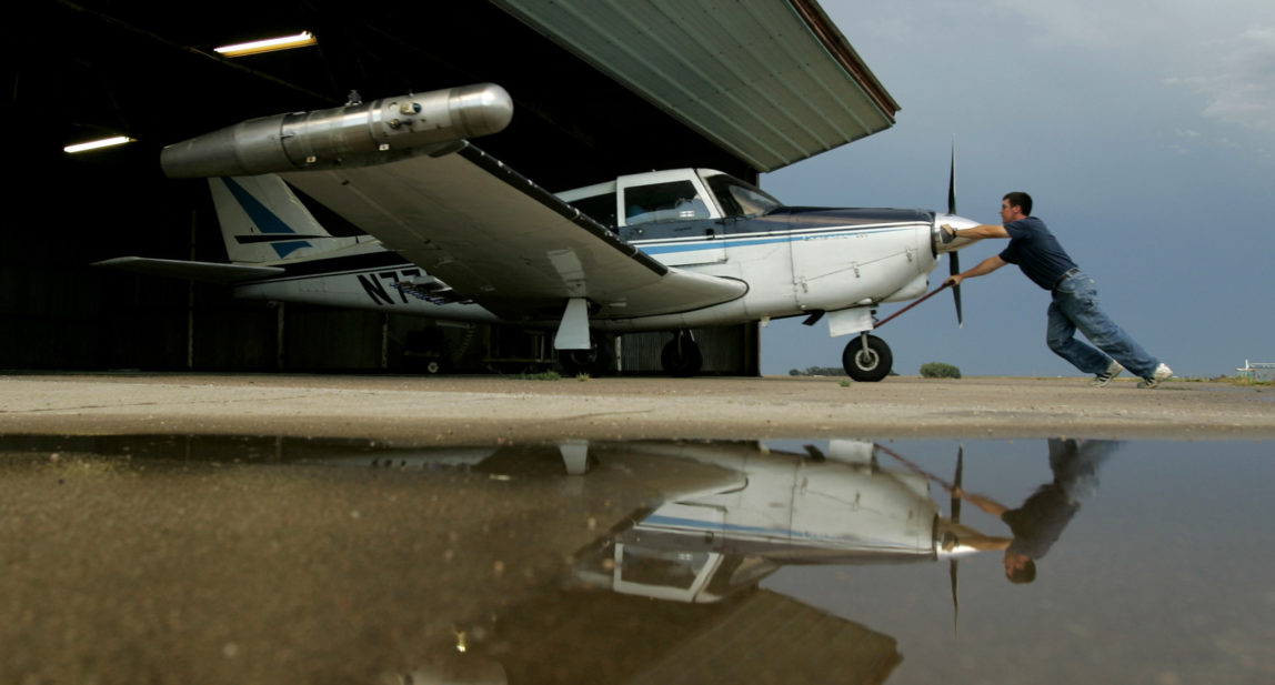 Scott Bryant pushes his plane into a hangar at the Lakin, Kan., airport after flying a cloud seeding mission for the Western Kansas Weather Modification program, Aug. 28, 2007. The program aims to reduce crop damage from hail by saturating storm clouds with silver iodide particles. (AP/Charlie Riedel)