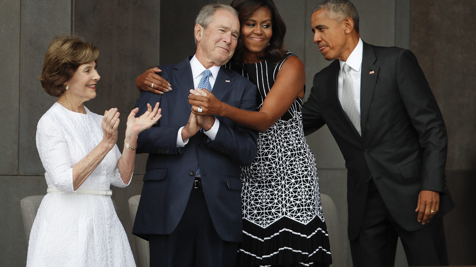 First lady Michelle Obama, center, hugs former President George W. Bush, as President Barack Obama and former first lady Laura Bush walk on stage at the dedication ceremony of the Smithsonian Museum of African American History and Culture on the National Mall in Washington, Saturday, Sept. 24, 2016. (AP/Pablo Martinez Monsivais)