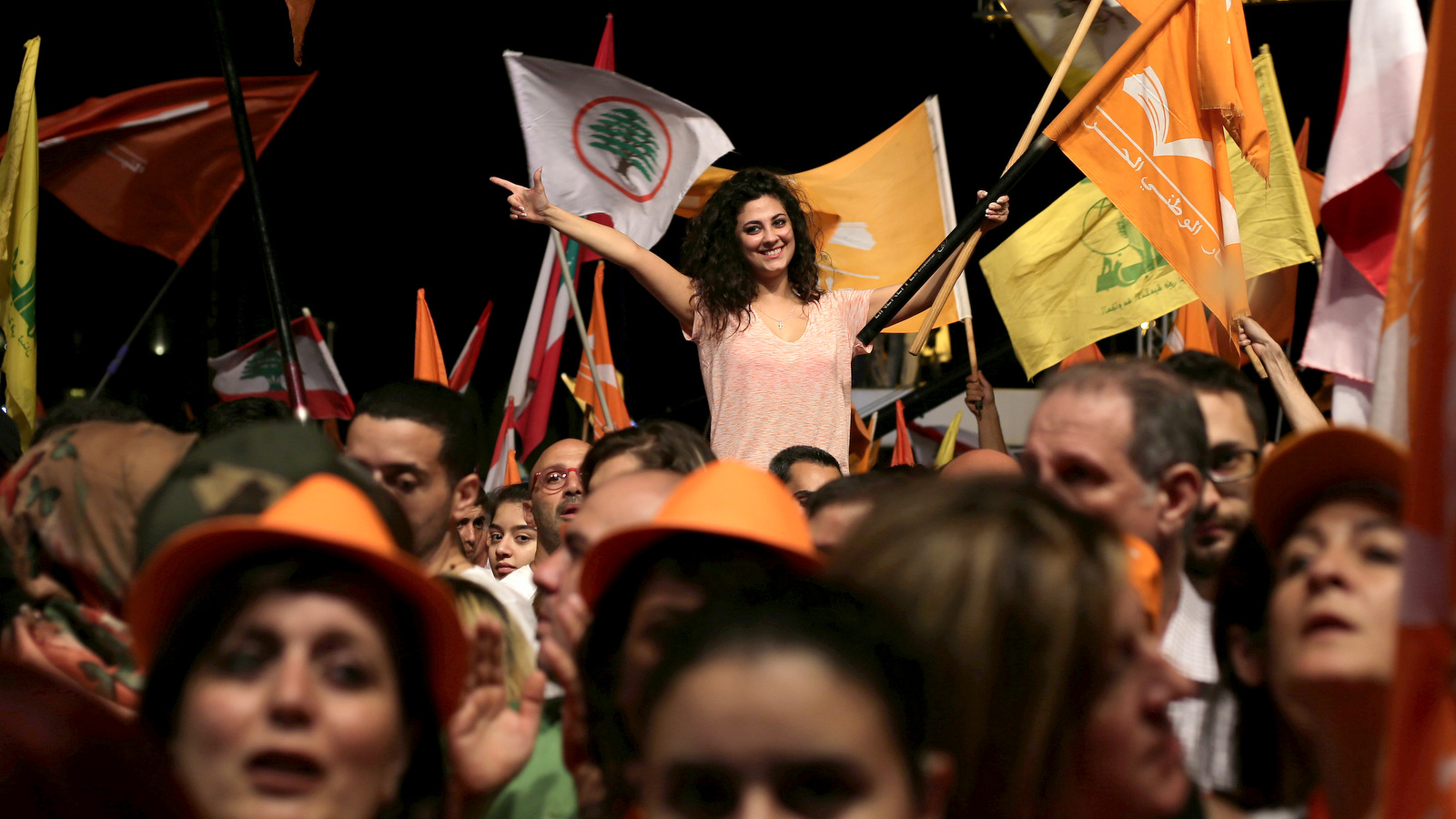 Supporters of newly-elected Lebanese President Michel Aoun, hold Free Patriotic Movement and Lebanese and Hezbollah flags during a rally celebrating the election of President Aoun, at Martyrs Square in downtown Beirut, Lebanon, Monday, Oct. 31, 2016. (AP/Hassan Ammar)