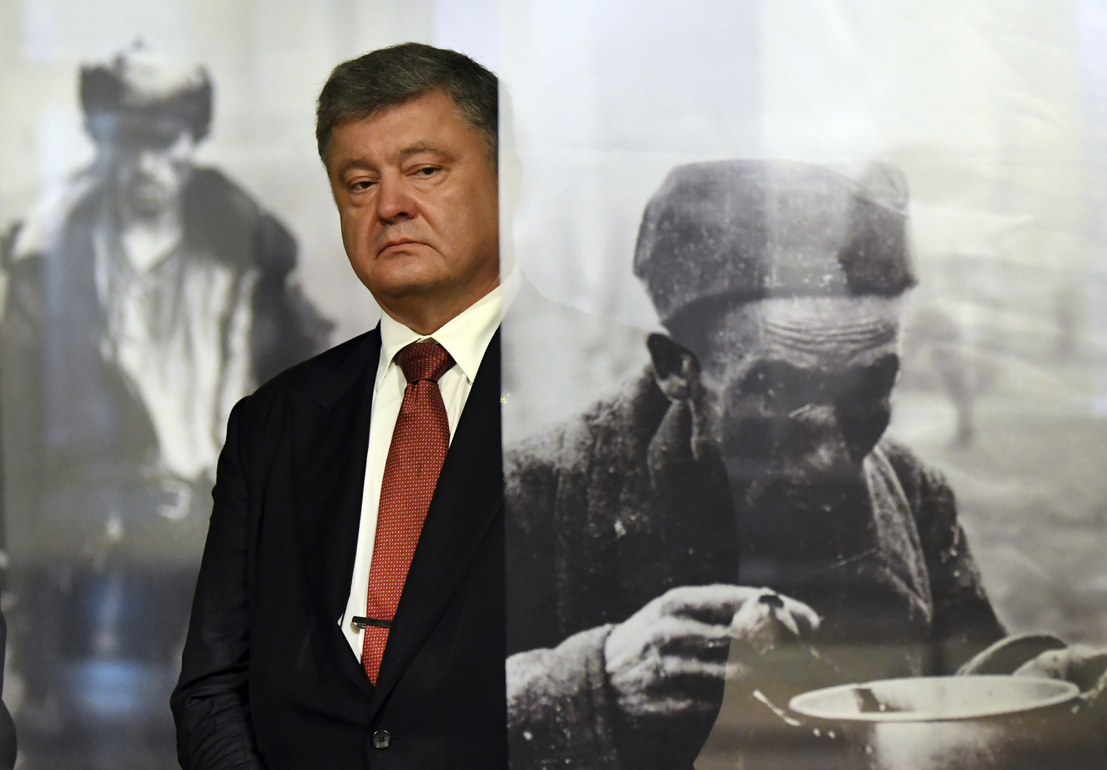 Ukrainian President Petro Poroshenko looks at pictures at an exhibition in the former Nazi concentration camp Sachsenhausen, Germany, Saturday, May 20, 2017. (Ralf Hirschberger/dpa via AP)