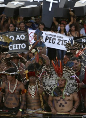 Indigenous protesters from various ethnic groups carry fake coffins representing indians killed over the demarcation of land, as they demand the demarcation of indigenous lands, outside the National Congress in Brasilia, Brazil, April 25, 2017. (AP Photo/Eraldo Peres)