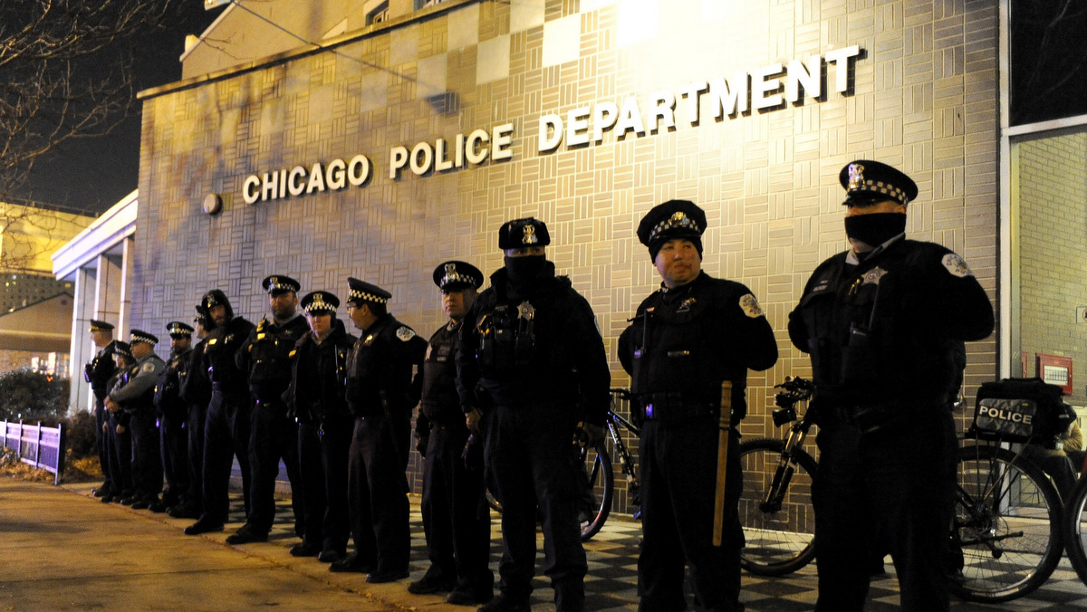 FILE - In this Nov. 24, 2015, file photo, Chicago police officers line up outside the District 1 central headquarters in Chicago, during a protest for the fatal police shooting of 17-year-old Laquan McDonald. Special prosecutor Patricia Brown-Holmes announced Tuesday, June 27, 2017, that three Chicago police officers were indicted on felony charges that they conspired to cover up the actions of Chicago Police Officer Jason Van Dyke in the killing of McDonald. The indictment, approved by a Cook County grand jury, alleges that one current and two former officers lied about the events of Oct. 20, 2014 when Van Dyke shot the black teenager 16 times. (AP Photo/Paul Beaty File)