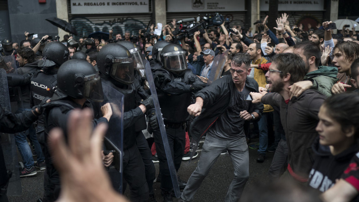 People confronts Spanish riot police near a voting site at a school assigned to be a polling station by the Catalan government in Barcelona, Spain, Sunday, 1 Oct. 2017.(AP/Felipe Dana, File)