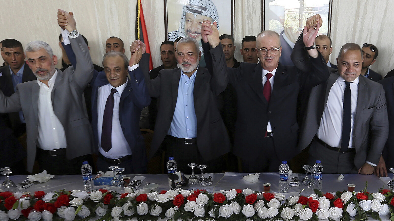 From left to right in front row, Hamas leader in the Gaza Strip Yahya Sinwar, Head of Palestinian General Intelligence Majid Faraj, Head of the Hamas political bureau Ismail Haniyeh, Palestinian Prime Minister Rami Hamdallah and an Egyptian mediator hold their hands up during a meeting in Gaza City, Monday, Oct. 2, 2017. (AP/Prime Minister Office)