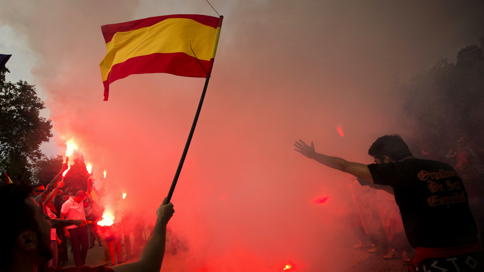 Extreme right-wing demonstrators burn Esteladas or independence flags as they hold an alternative celebration for Spain's National Day in Barcelona, Spain, Thursday, Oct. 12, 2017. A few hundred demonstrators attended alternative celebrations as thousands of other Spaniards gathered in Barcelona as Spain's celebrates its national day amid one of the country's biggest crises ever as its powerful northeastern region of Catalonia threatens independence. (AP Photo/Emilio Morenatti)