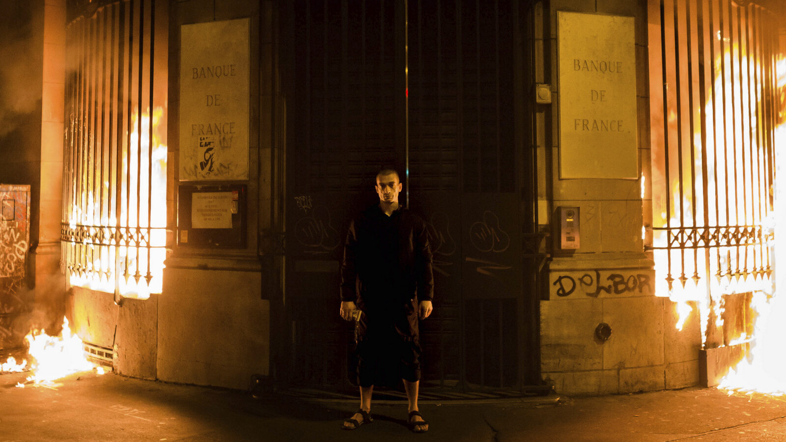 Russian artist Petr Pavlensky poses in front of a Banque de France building after setting fire to the window gates as part of a performance in Paris, Monday, Oct. 16, 2017. Pavlensky, known for macabre, politically charged actions, was being detained by police. (AP/Capucine Henry)