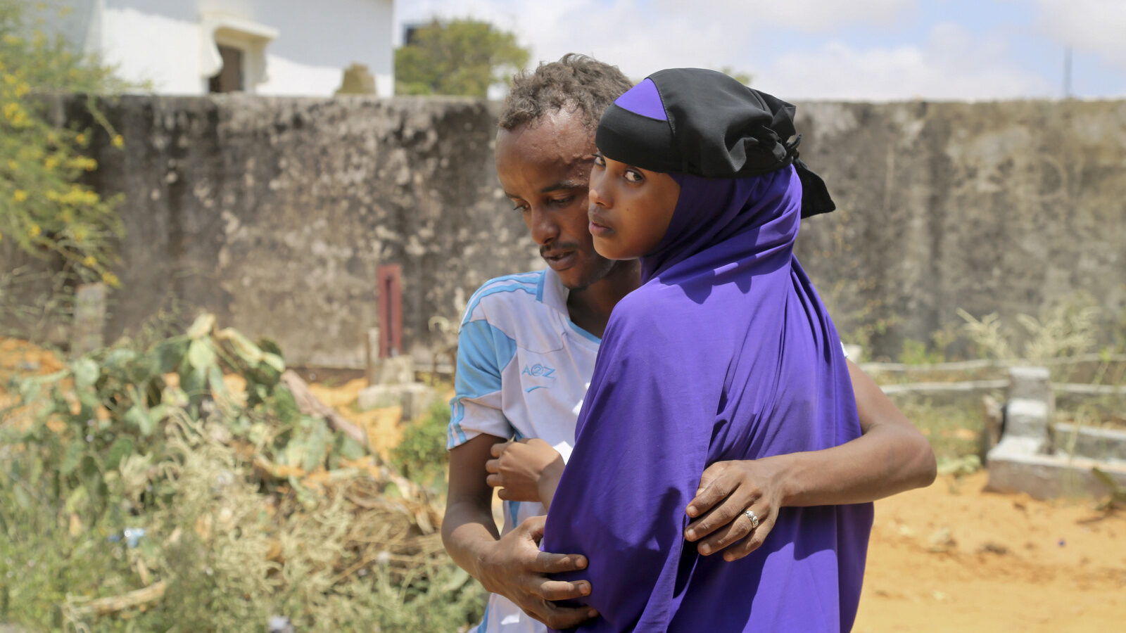 Zakariye Abdirisaq, left, who lost both his father and aunt in the bombing, is comforted by his cousin as they stand next to his father's grave, at a cemetery in Mogadishu, Somalia Tuesday, Oct. 17, 2017. Anguished families gathered across Somalia's capital on Tuesday as funerals continued for the more than 300 people killed in one of the world's deadliest attacks in years, while others waited anxiously for any word of the scores of people still said to be missing. (AP/Mohamed Sheikh Nor)