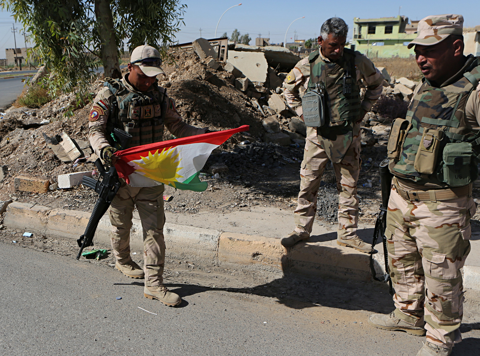 Iraqi soldiers remove a Kurdish flag from a checkpoint in Bashiqa, Iraq, Oct. 18, 2017. Iraqi forces retook control of the town on the northeastern outskirts of Mosul. Kurdish forces pulled out of disputed areas across northern and eastern Iraq a day after handing Kirkuk to federal forces amid a tense standoff following last month's vote for independence. (AP/Khalid Mohammed)