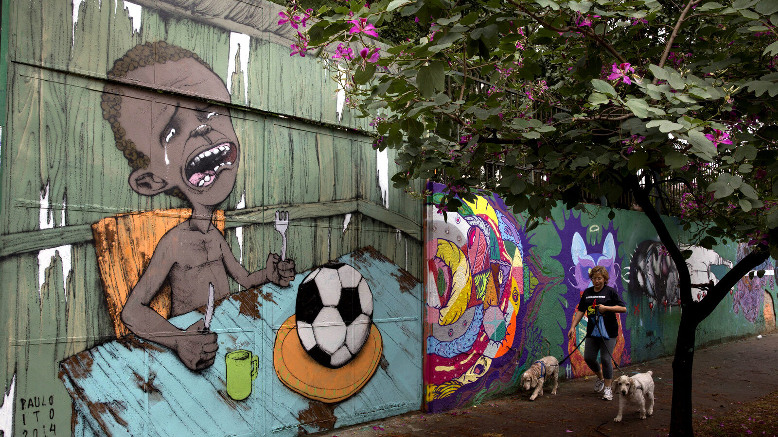 A mural by Brazilian street artist Paulo Ito, of a crying child who is served a soccer ball to appease his hunger, in Sao Paulo, Brazil. Prosecutors in Brazil's largest city opened an inquiry on Oct. 19, 2017, into the mayor's plans to offer school meals with pellets made of reprocessed food items. (AP/Andre Penner)